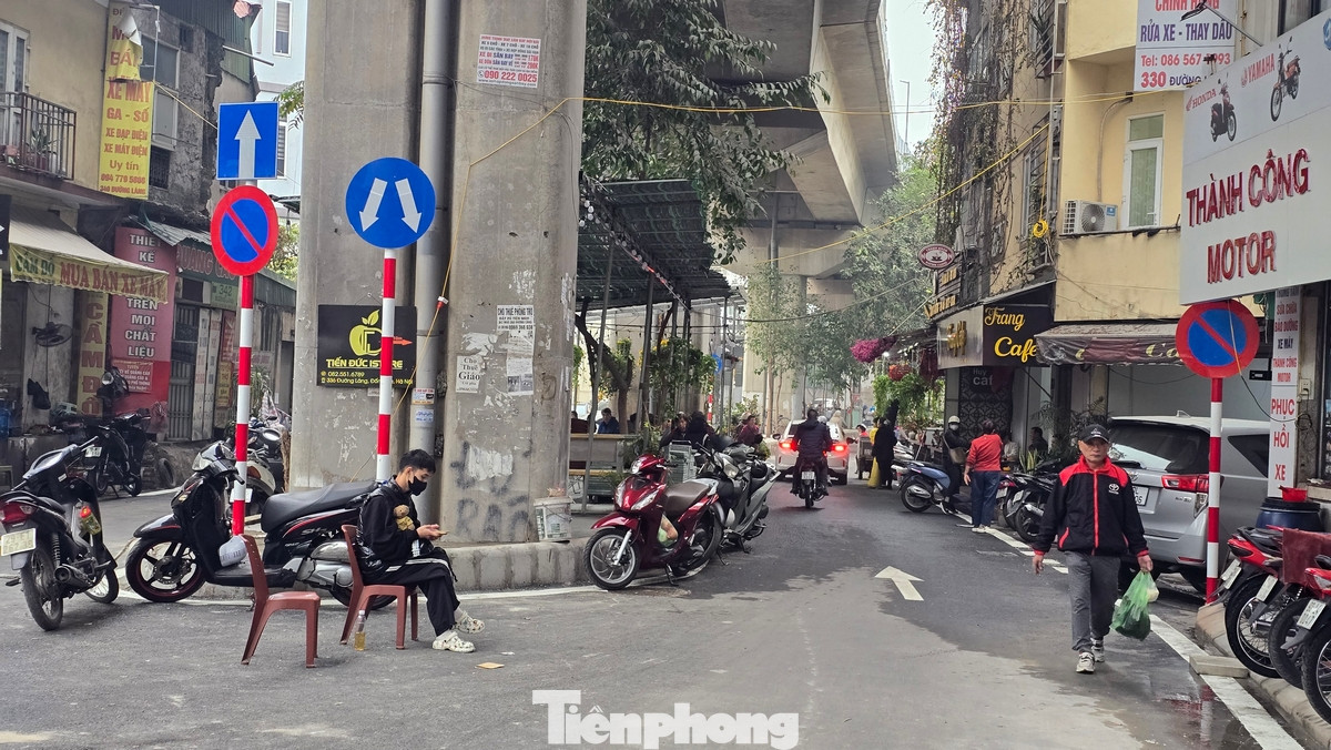 Cả hai phần làn đường đã bị chiếm dụng thành những bãi đỗ xe máy, ô tô. Dải phân cách lớn ngay dưới cầu đường sắt biến thành nơi kinh doanh cà phê.