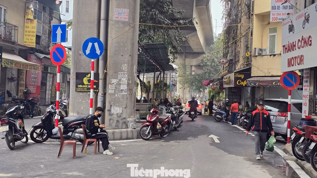 Cả hai phần làn đường đã bị chiếm dụng thành những bãi đỗ xe máy, ô tô. Dải phân cách lớn ngay dưới cầu đường sắt biến thành nơi kinh doanh cà phê.