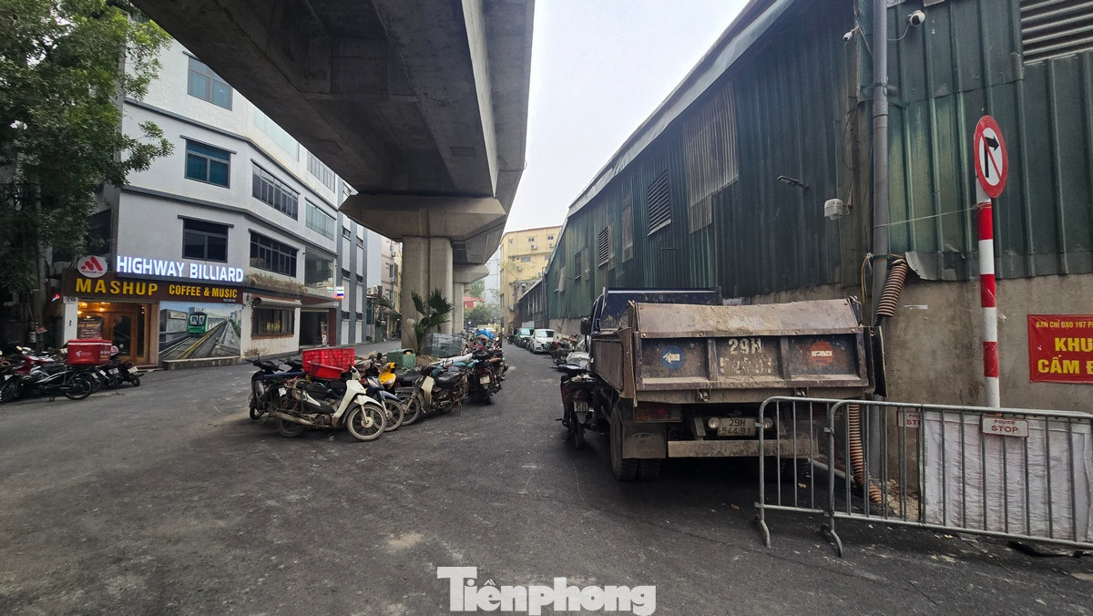 Cả hai phần làn đường đã bị chiếm dụng thành những bãi đỗ xe máy, ô tô. Dải phân cách lớn ngay dưới cầu đường sắt biến thành nơi kinh doanh cà phê.