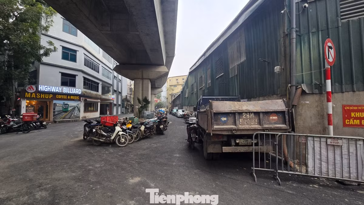 Cả hai phần làn đường đã bị chiếm dụng thành những bãi đỗ xe máy, ô tô. Dải phân cách lớn ngay dưới cầu đường sắt biến thành nơi kinh doanh cà phê.