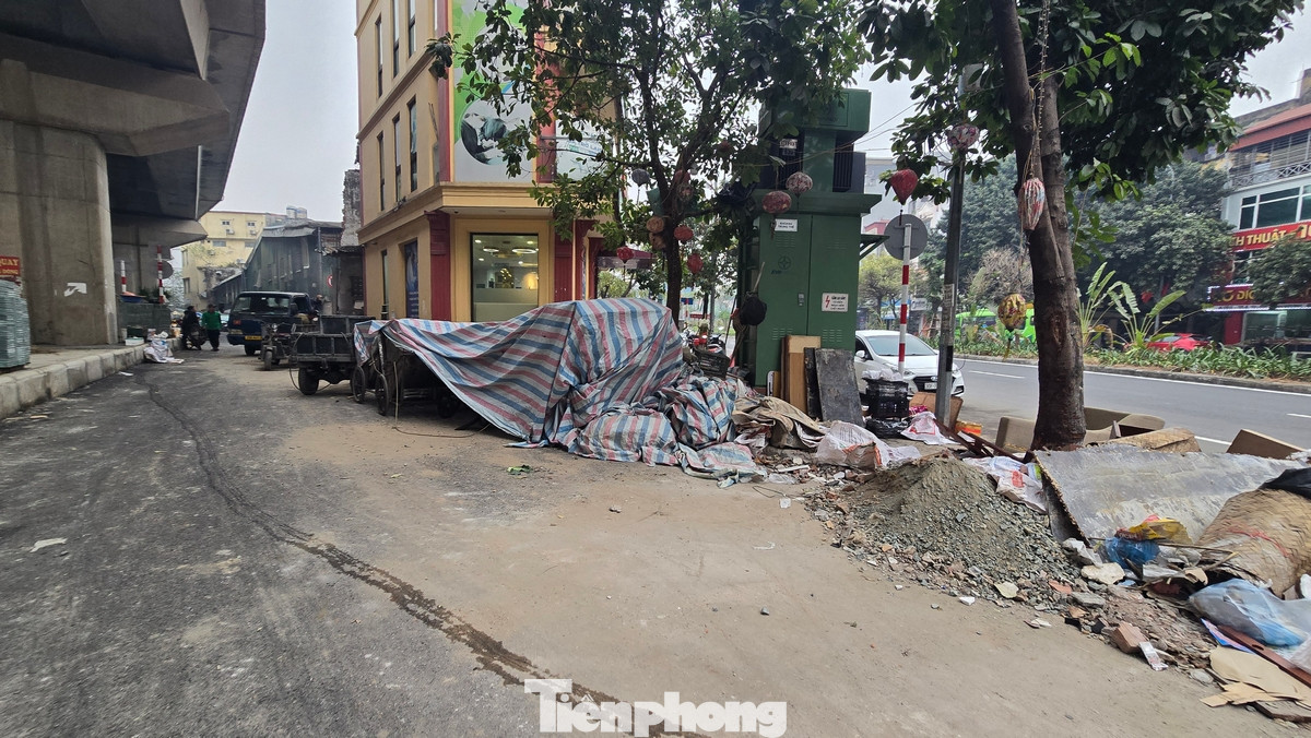 Vật liệu xây dựng được các hộ dân gần đó tập kết lộn xộn, tràn ra lòng đường.