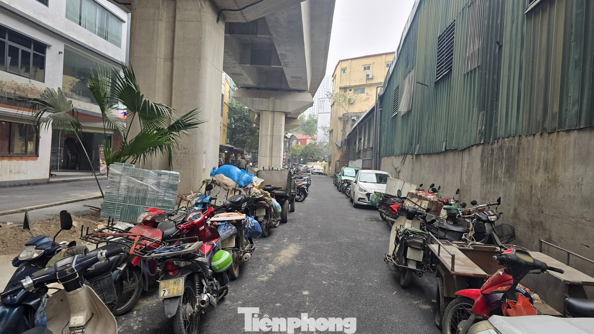 Cả hai phần làn đường đã bị chiếm dụng thành những bãi đỗ xe máy, ô tô. Dải phân cách lớn ngay dưới cầu đường sắt biến thành nơi kinh doanh cà phê.