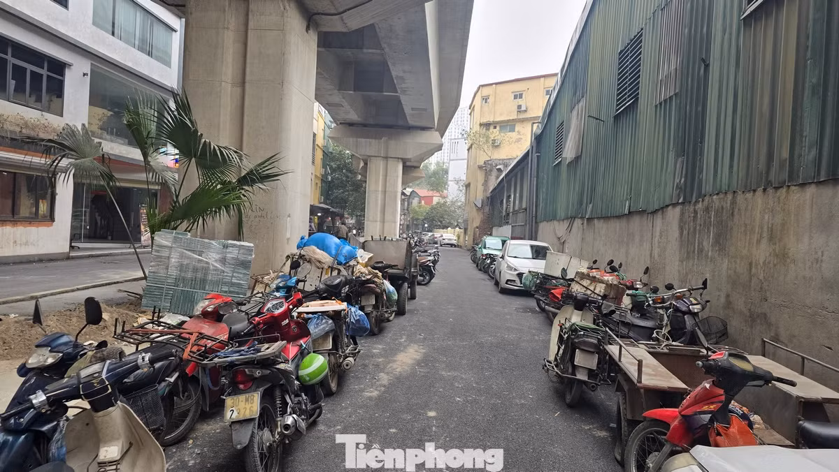 Cả hai phần làn đường đã bị chiếm dụng thành những bãi đỗ xe máy, ô tô. Dải phân cách lớn ngay dưới cầu đường sắt biến thành nơi kinh doanh cà phê.