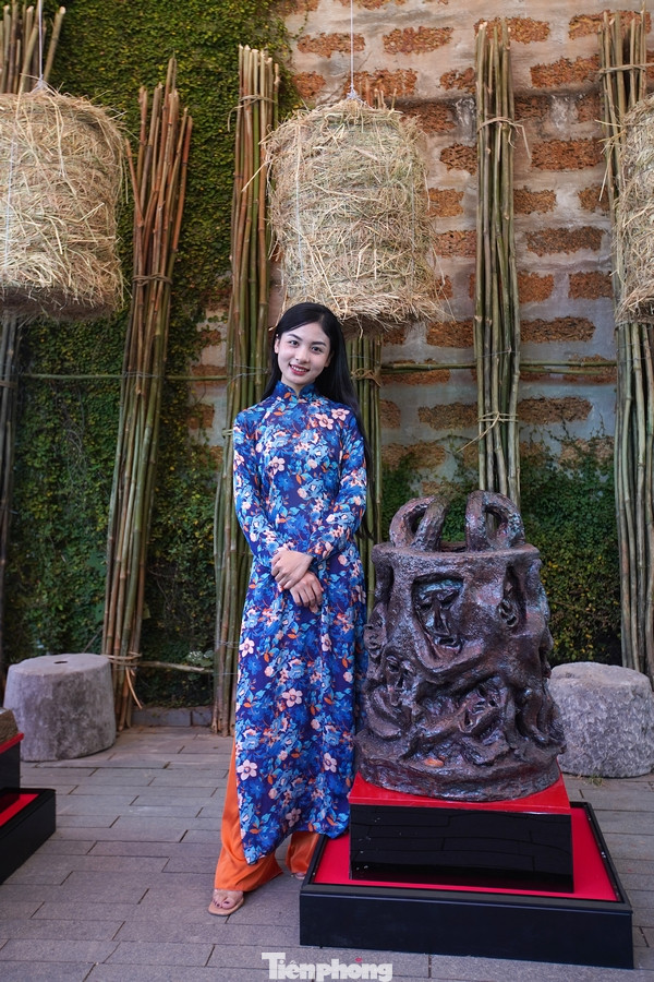 Một số bạn trẻ thích thú chụp hình bên những tác phẩm "độc - lạ" tại triển lãm của họa sĩ Ngô Xuân Bính.