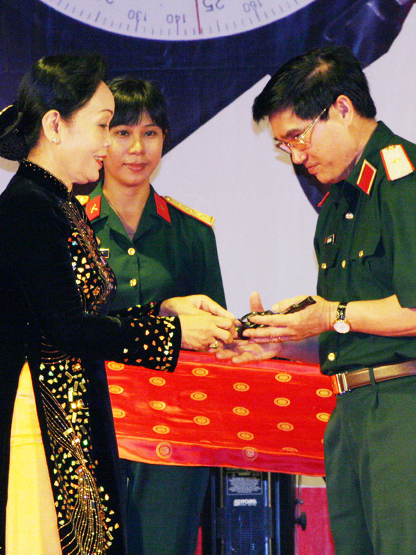 Thiếu tướng Lê Mã Lương tiếp nhận khẩu súng ngắn của cố Trung tướng Nguyễn Văn Tấn - Nguyên tư lệnh quân khu 9, do phu nhân của Trung tướng trao tặng. Ảnh: Ngọc Đinh