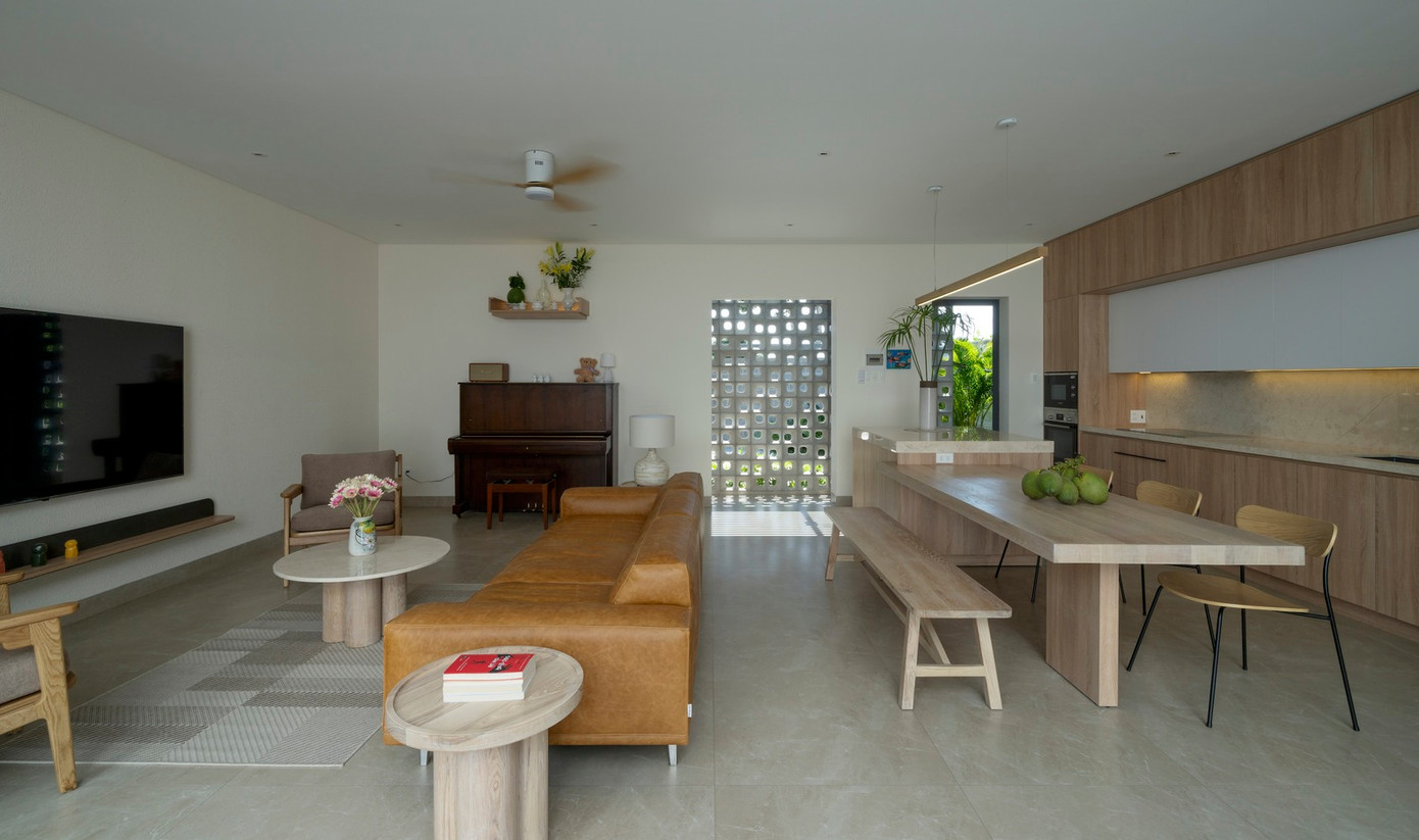 Không gian sinh hoạt chung được che chắn khéo léo bằng bức tường bông gió trước sảnh trải nệm, nhằm giảm nhiệt và tạo sự riêng tư. Hai bên phòng khách và bếp được mở rộng tối đa. Không gian sinh hoạt chung được che chắn khéo léo bằng bức tường bông gió trước sảnh trải nệm, nhằm giảm nhiệt và tạo sự riêng tư. Hai bên phòng khách và bếp được mở rộng tối đa.