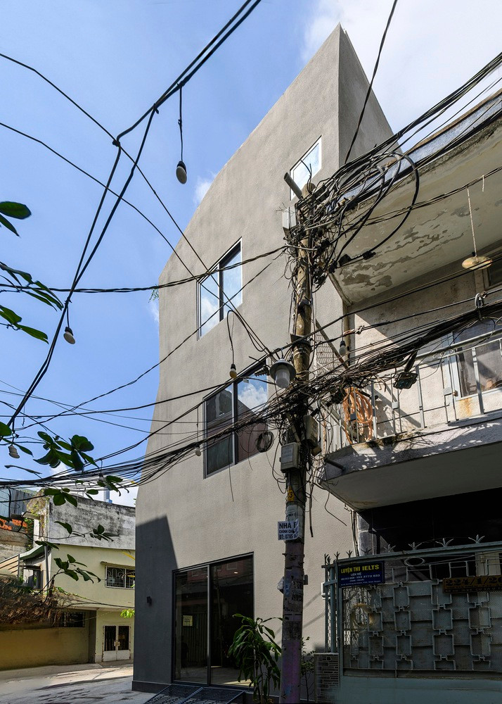 Do đó, cửa ra vào và cửa sổ hình vuông được bố trí ngẫu nhiên trên ba mặt tiền màu xám, có kết cấu thô.