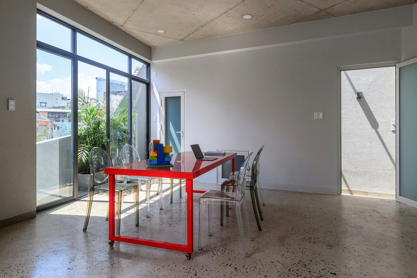 Không gian nội thất được hoàn thiện bằng bảng màu vật liệu đơn giản, bao gồm sàn bê tông đánh bóng và trần bê tông lộ ra ngoài kết hợp với tường kính và sơn.