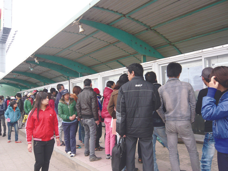 Công nhân đến tìm hiểu thông tin tuyển dụng ngày 31-1 tại bảng thông tin KCN Thăng Long, Đông Anh, Hà Nội. Ảnh: Phong Cầm