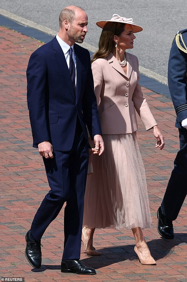 Kate để kiểu tóc nâu xõa với lọn tóc xoăn nhẹ nhàng và thanh lịch. Trong khi đó, Hoàng tử William trung thành với vest màu xanh navy đậm cổ điển. Ảnh: Reuters/PA.