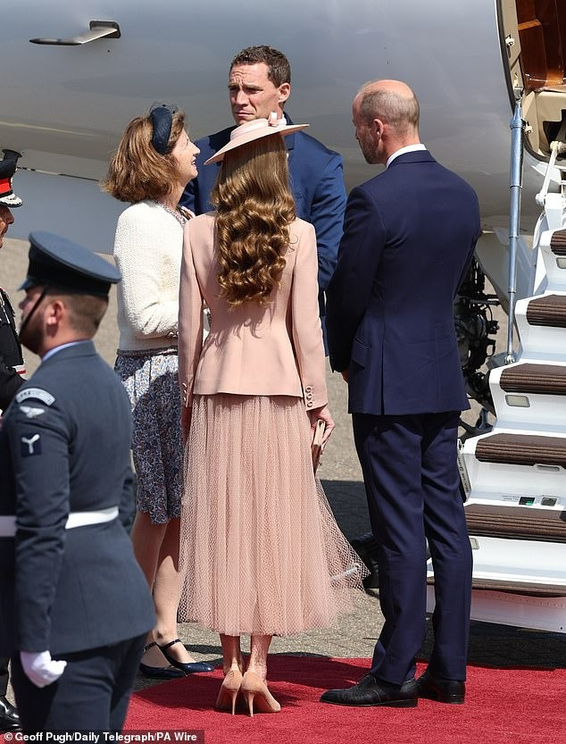 Kate để kiểu tóc nâu xõa với lọn tóc xoăn nhẹ nhàng và thanh lịch. Trong khi đó, Hoàng tử William trung thành với vest màu xanh navy đậm cổ điển. Ảnh: Reuters/PA.