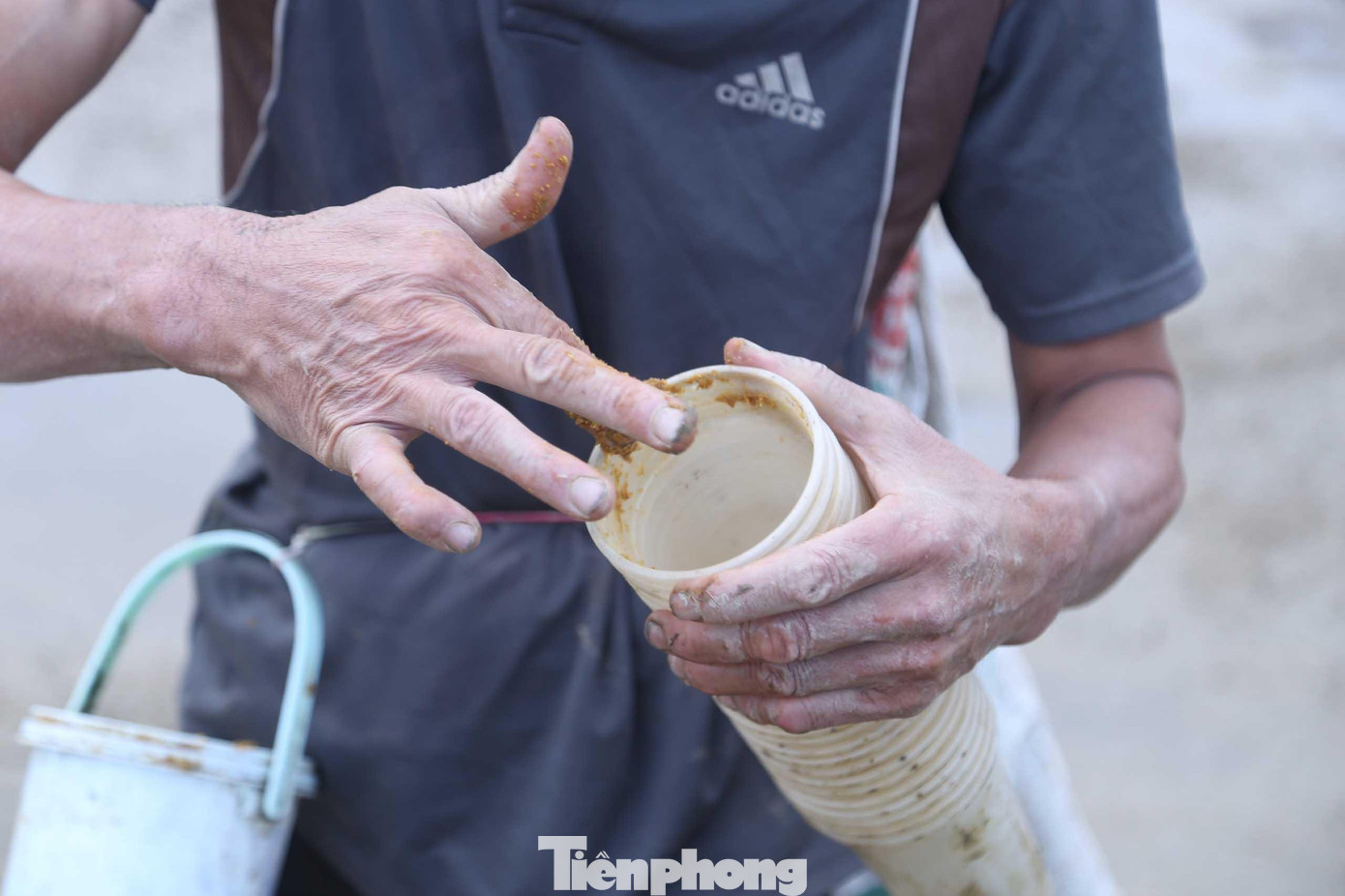 Ông Quế dùng tay lấy một ít mồi, xoa đều vào thành cốc từ miệng vào khoảng 5cm. Cách này không tốn mồi nhưng dễ dàng dụ những con cáy trốn kỹ trong hang ra. Khi bò theo mùi thức ăn, cáy sẽ rơi hẳn vào trong cốc. Ông Quế dùng tay lấy một ít mồi, xoa đều vào thành cốc từ miệng vào khoảng 5cm. Cách này không tốn mồi nhưng dễ dàng dụ những con cáy trốn kỹ trong hang ra. Khi bò theo mùi thức ăn, cáy sẽ rơi hẳn vào trong cốc.