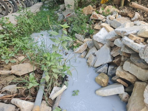 Nước thải của Công ty cổ phần khai thác chế biến đá Thanh Xuân chảy ra môi trường, có màu trắng đục.