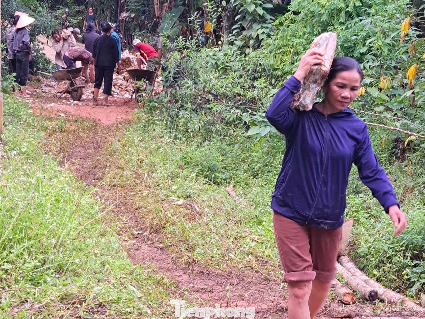 Người dân vác đá lắp, ghép trên 10 mét qua suối Hung ở bản Minh Châu.