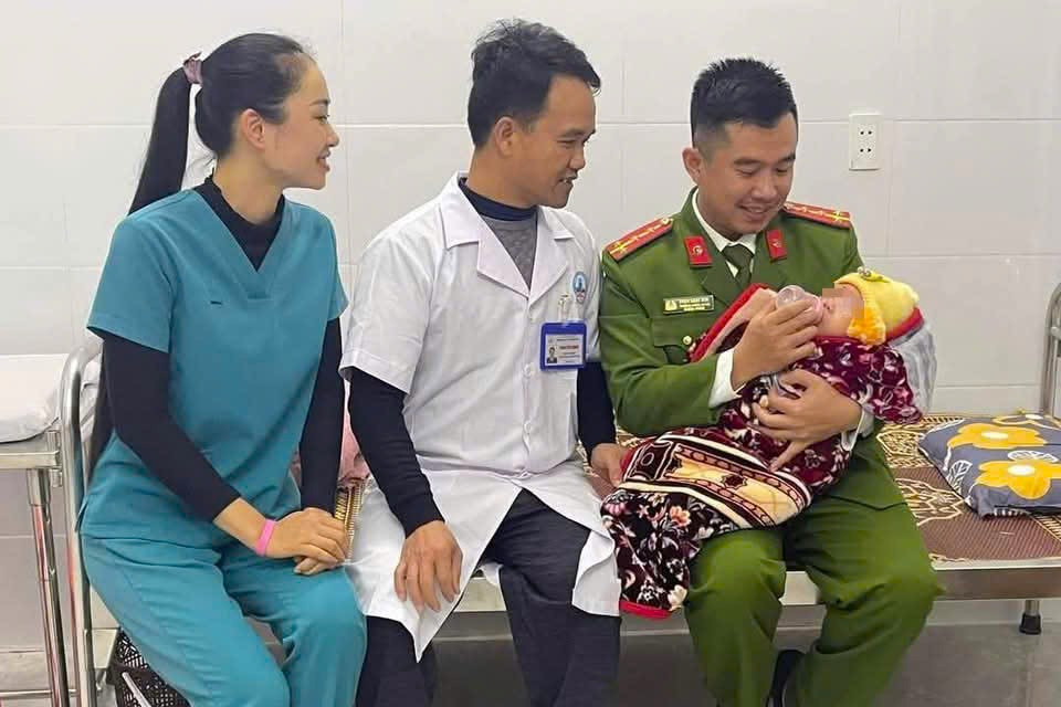 Cán bộ công an xã phối hợp nhân viên y tế xã Hương Sơn chăm sóc cháu bé