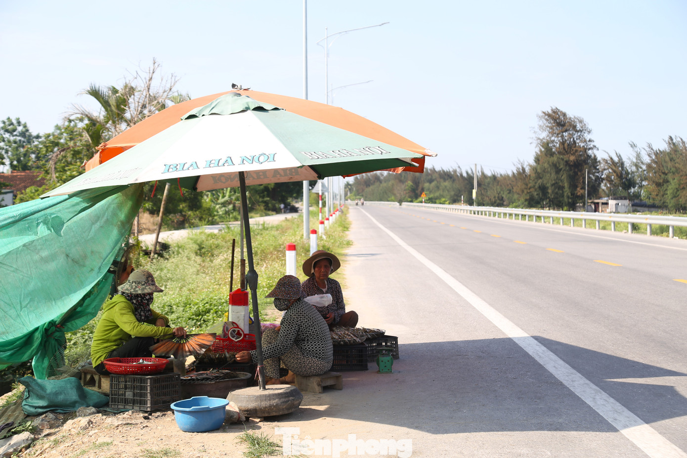 Những phụ nữ làng biển nhóm bếp than ngay trước cổng nhà, dọc tuyến đường ven biển để nướng cá.