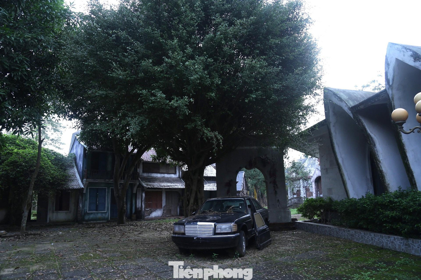 Một chiếc xe ô tô đã hư hỏng được bỏ lại tại sân nhà chiếu hình vũ trụ.