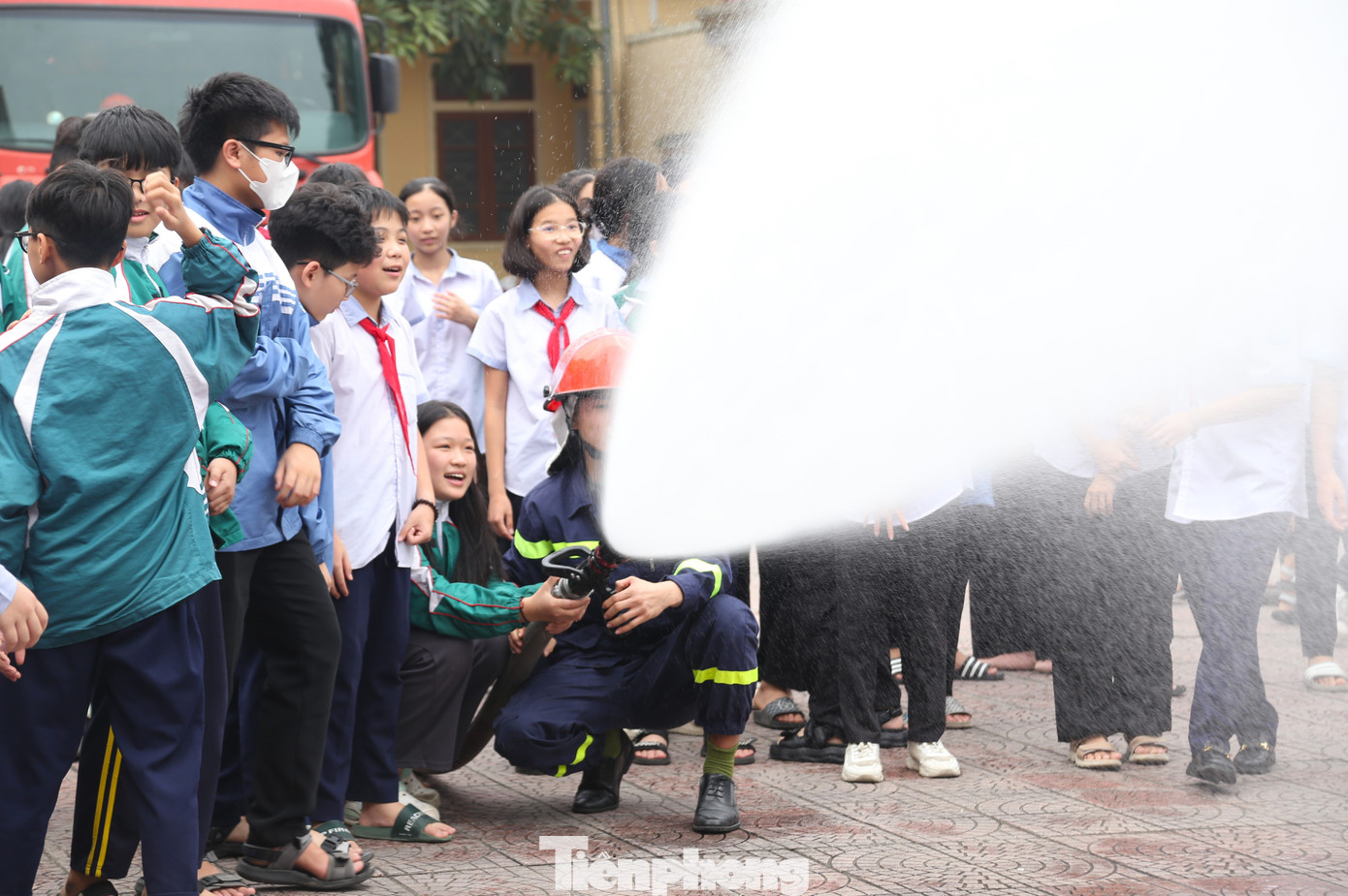 Cán bộ, chiến sĩ PCCC&amp;CNCH hướng dẫn học sinh, sinh viên cách phun vòi nước chữa cháy hiệu quả.