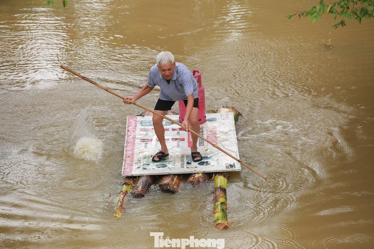 Người dân di chuyển khó khăn trong nước lũ.