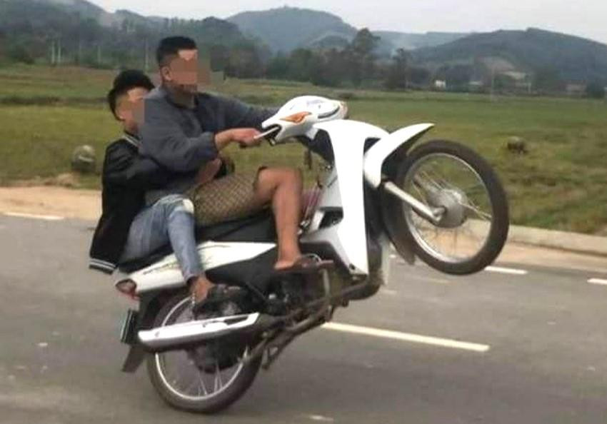Hình ảnh hai thanh niên bốc đầu xe máy
