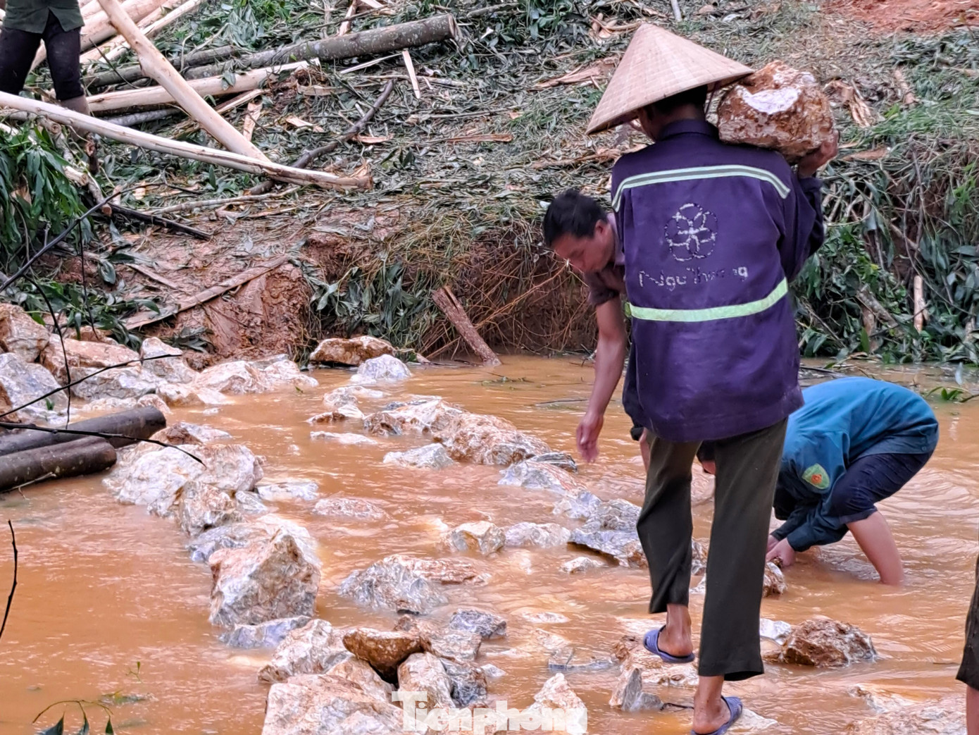 Người dân vác đá lắp, ghép trên 10 mét qua suối Hung ở bản Minh Châu.
