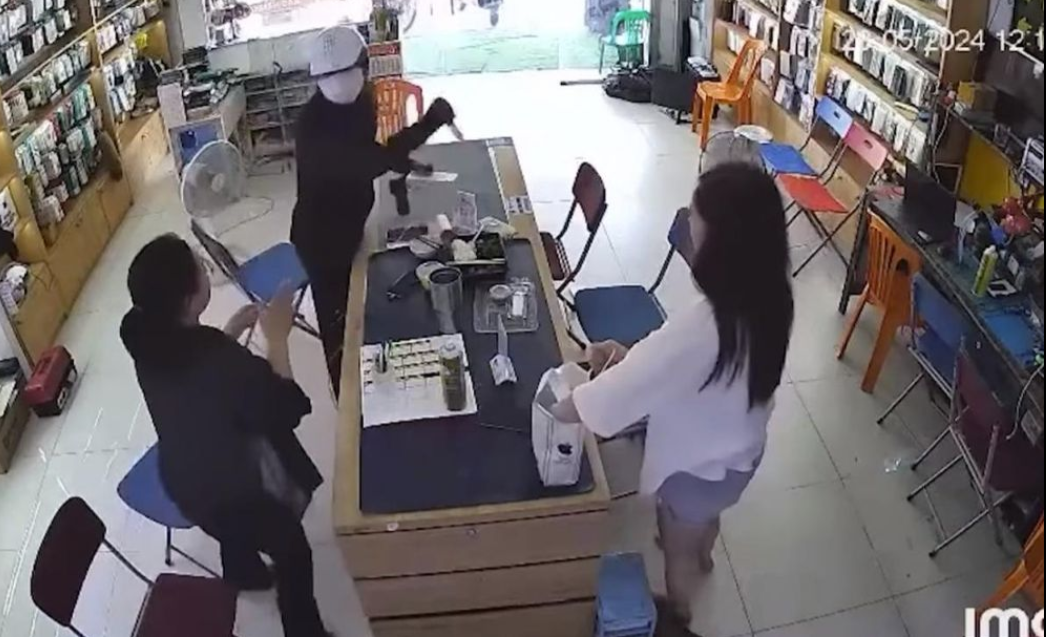 Hình ảnh tên cướp vung dao đe dọa cướp tài sản. (Ảnh cắt từ video)
