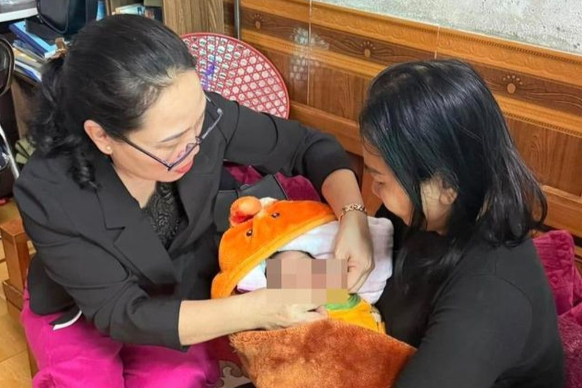 Cháu bé đang được bà M. chăm sóc Cháu bé đang được bà M. chăm sóc