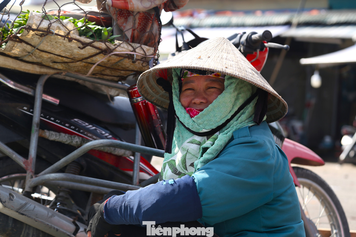 Khuôn mặt giấu dưới chiếc khăn trùm kín đầu và chiếc nón lá - đó là cách người phụ nữ này chống chọi với nắng nóng.