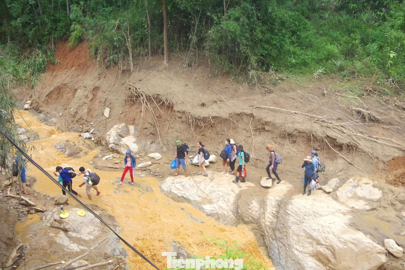 Các giáo viên phải đi ngay dưới con suối vừa mới bị lũ tàn phá