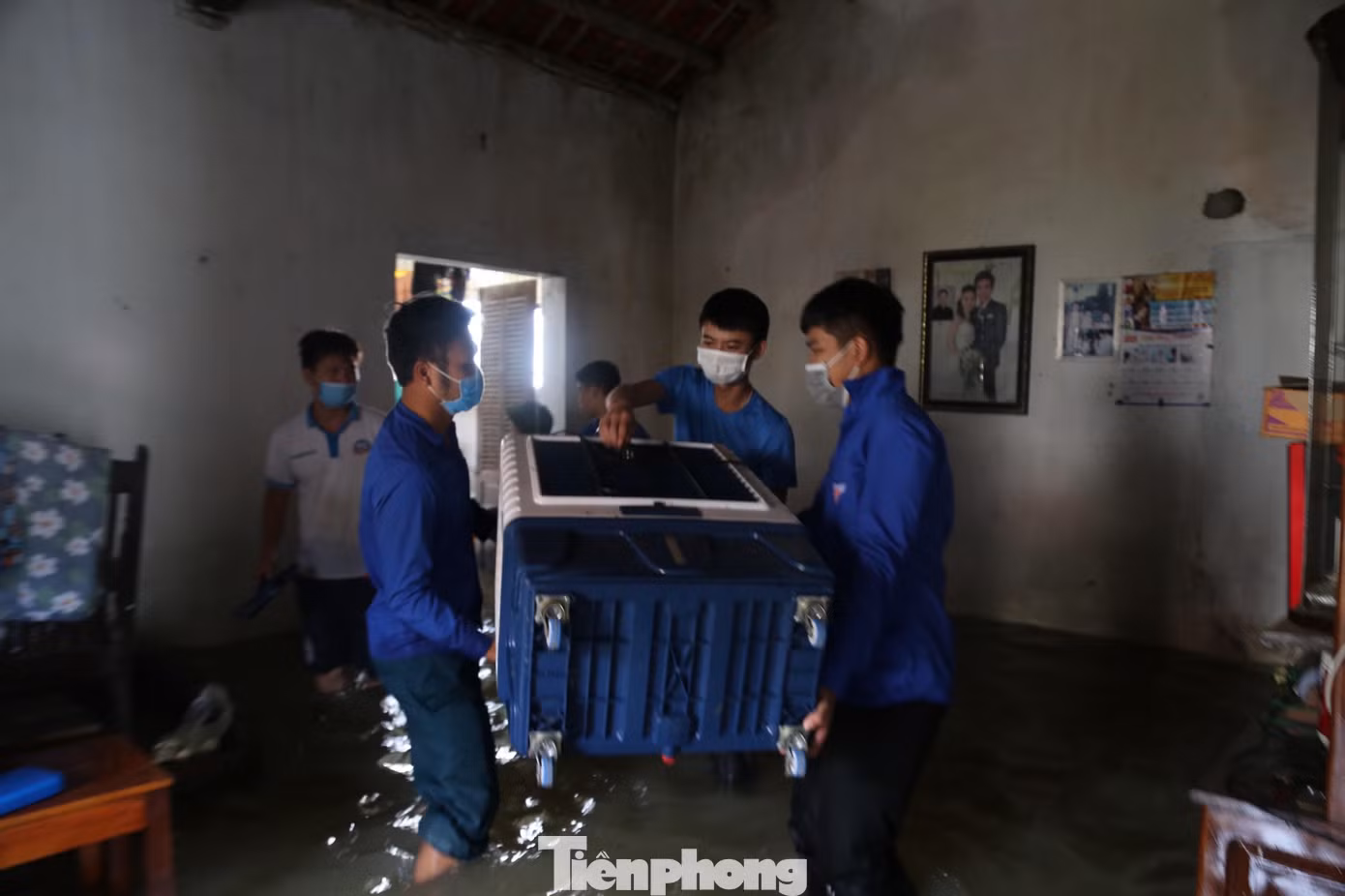 Nước ngập nhà, ĐVTN khiêng các vật dụng bàn ghế, tài sản ra ngoài giúp người dân.