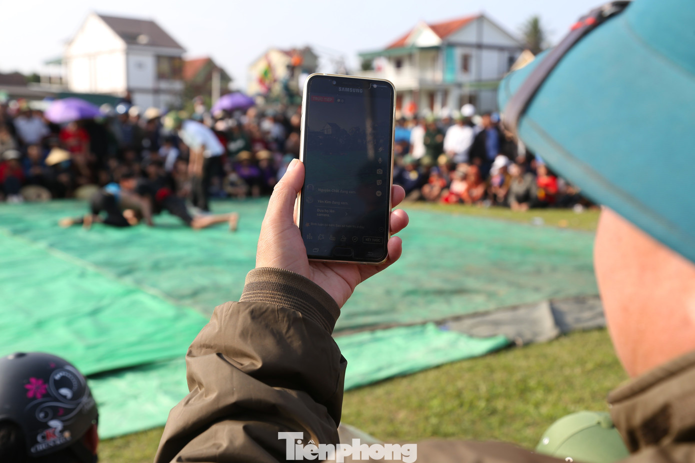 Người dân livestream cuộc tranh tài của các đô vật.