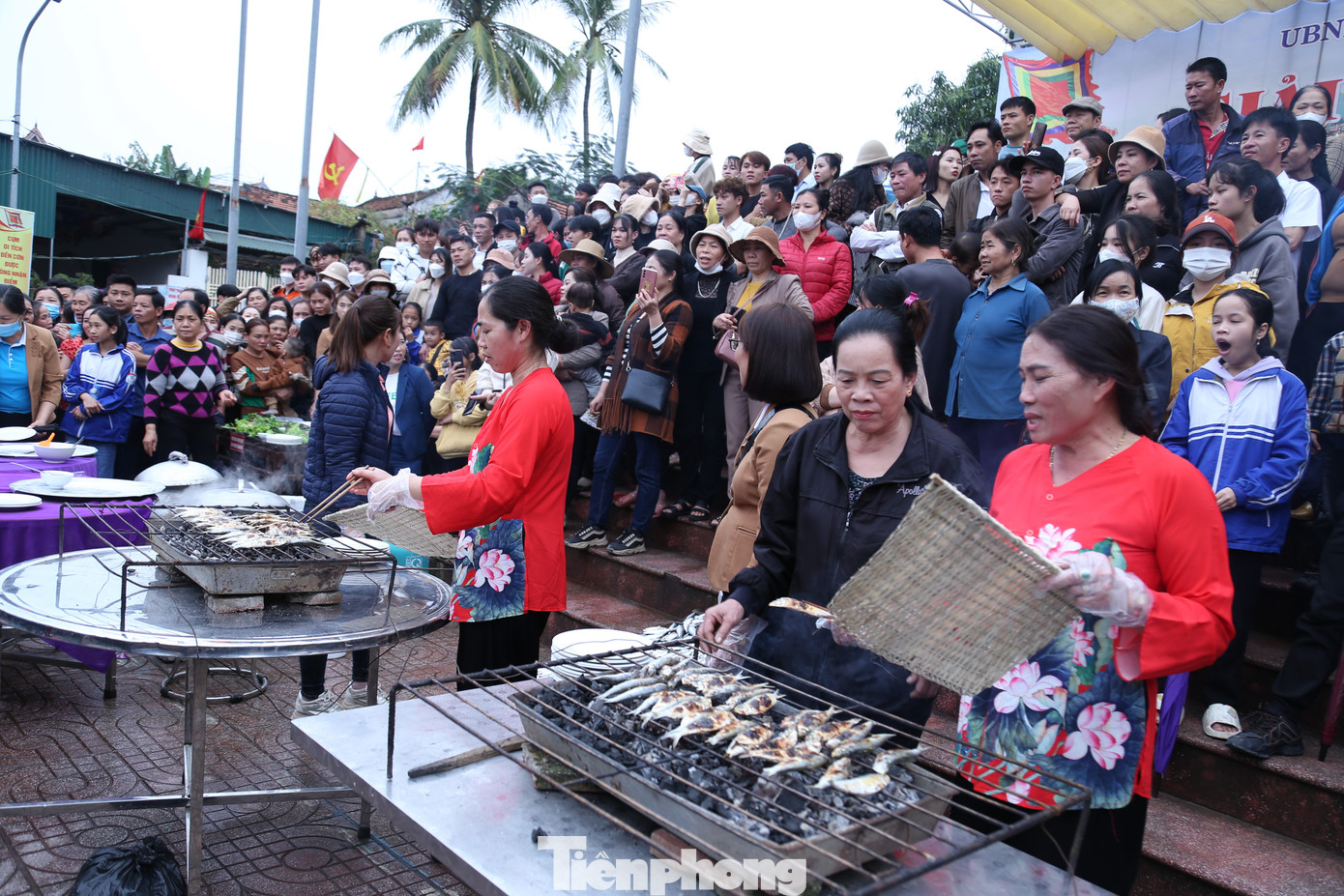 Gần đó, Hội phụ nữ phường Quỳnh Phương tổ chức nướng cá trích. Bên bếp than hồng, người phụ nữ một tay quạt than, tay kia lật từng con cá trích nướng vừa chín tới. Mùi cá trích nướng thơm ngậy.
