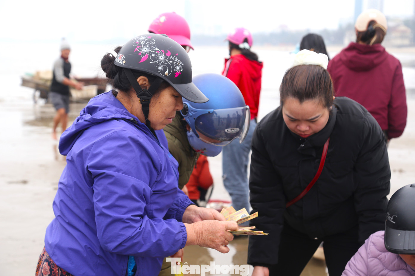 Cảnh mua bán huyên náo, tấp nập một góc bãi biển lúc sáng sớm.