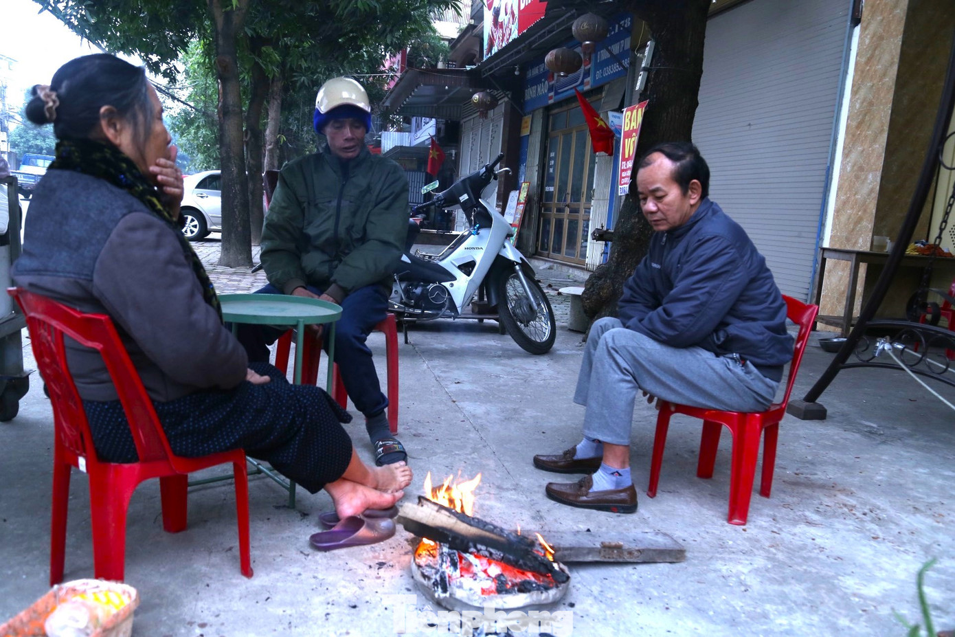 Để chống chọi lại cái rét, người dân đã đốt lửa sửa ấm. Để chống chọi lại cái rét, người dân đã đốt lửa sửa ấm.