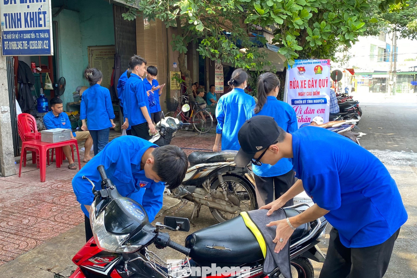 Tại phường Quang Tiến, thị xã Thái Hòa, hơn 20 đoàn viên thanh niên miệt mài cọ rửa từng vết dơ trên xe của khách bằng xà bông, tiếp đó rửa sạch bằng nước.