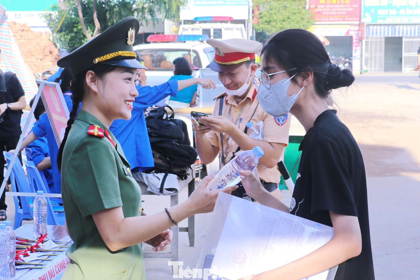 Nữ cán bộ Công an phát nước uống cho thí sinh.