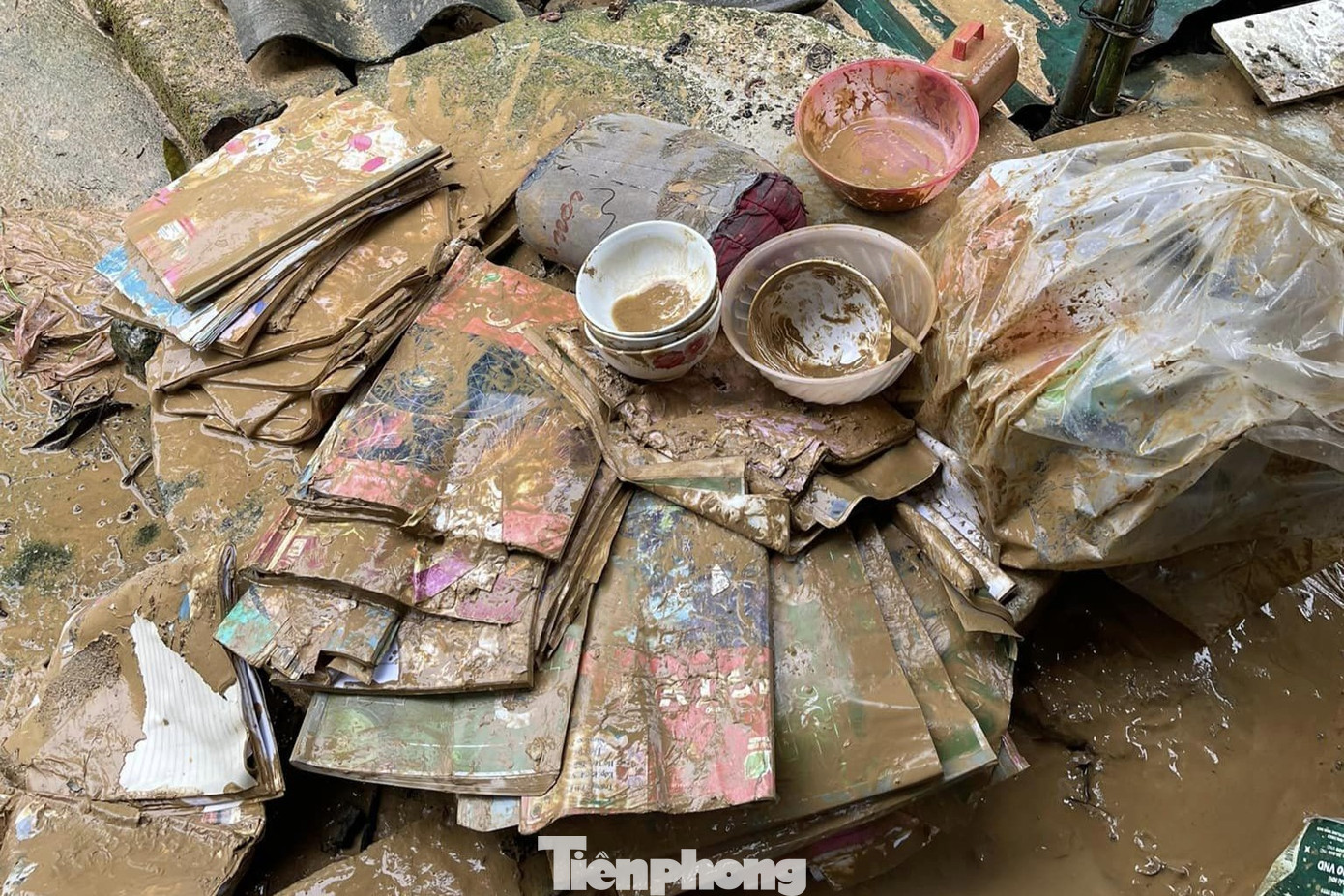 Sách vở của các em lấm lem bùn đất. Sách vở của các em lấm lem bùn đất.