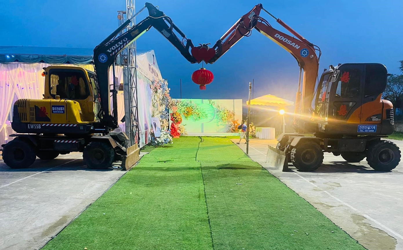 Cổng cưới được dựng bằng hai chiếc máy xúc nổi bật về đêm.