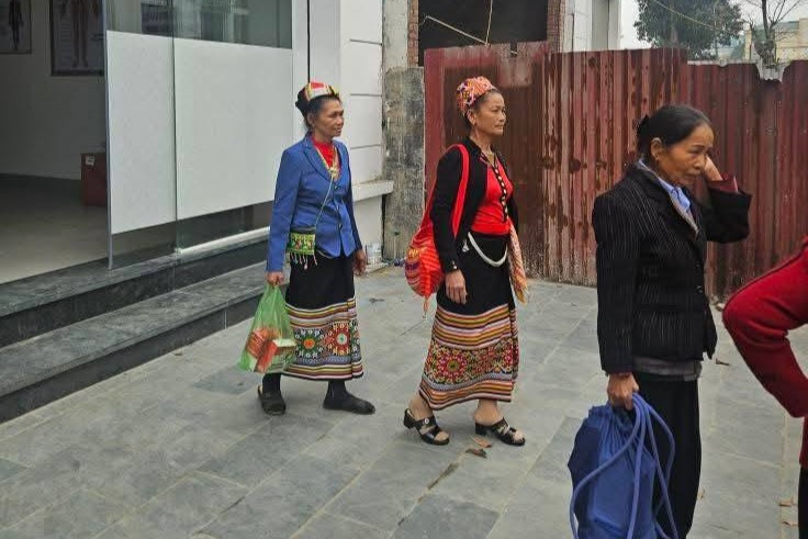 Một số người mặc trang phục dân tộc thiểu số rời nơi tổ chức hội thảo với một số sản phẩm