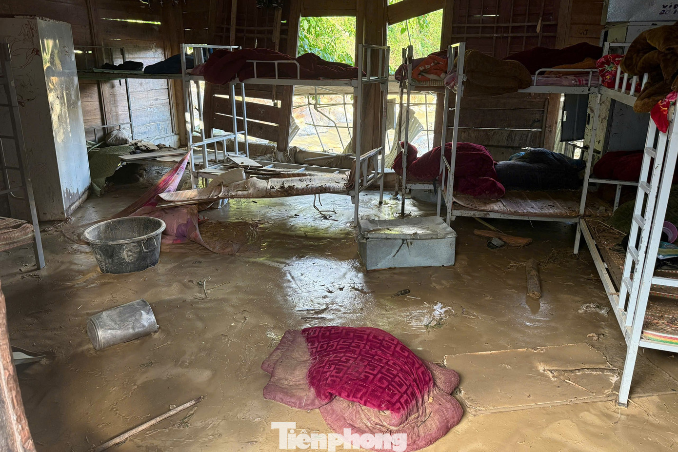 Sách vở, dụng cụ học tập, sinh hoạt của học sinh, đồ dùng giảng dạy của giáo viên bị ướt sũng, nằm rải rác giữa bùn đất.