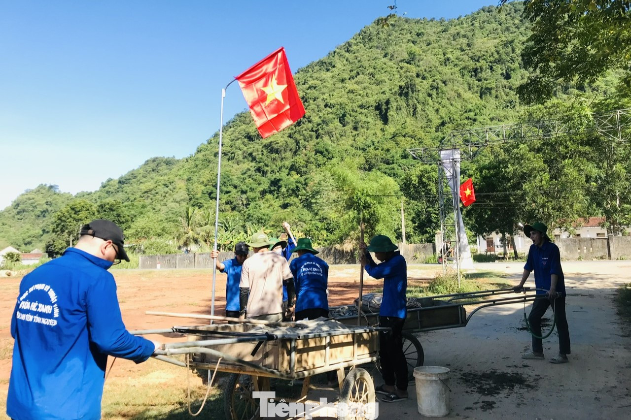 Lá cờ bay phấp phới trên nền trời trong xanh ở bản làng xa xôi là biểu tượng của sự đoàn kết, tinh thần và niềm tự hào dân tộc.