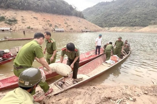 Lực lượng công an dùng thuyền đưa vật liệu vào nơi xây dựng, hỗ trợ làm móng nhà...