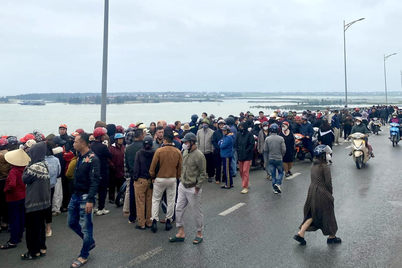 Rất đông người dân đứng trên cầu Cửa Hội theo dõi lực lượng chức năng tìm kiếm chị T.