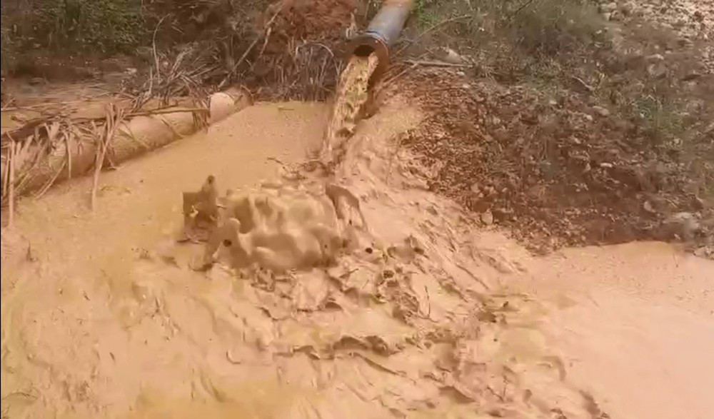 Nước thải đổ theo đường ống ra môi trường ở một mỏ quặng