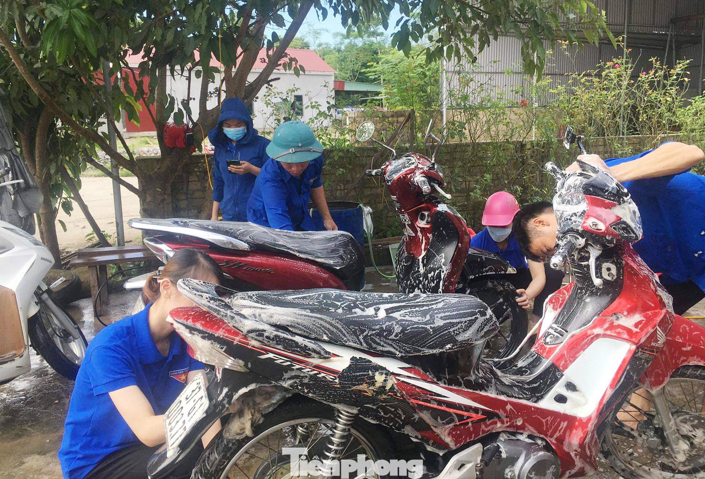 Nhân viên rửa xe là những chàng trai cô gái mặc màu áo xanh tình nguyện.