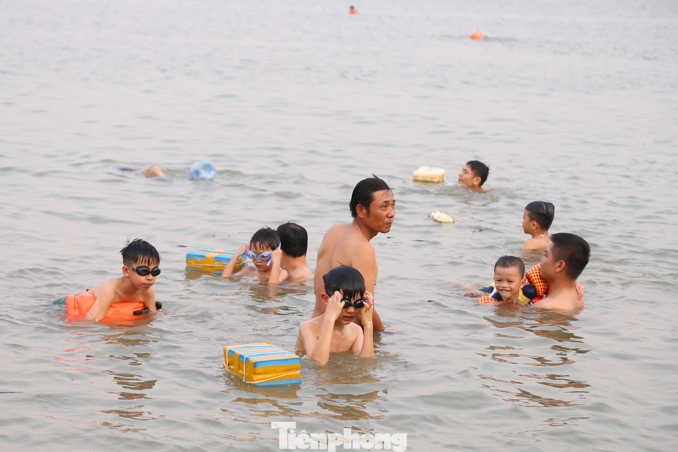 Các em nhỏ được trang bị áo phao, kính lặn, tắm cùng người lớn để đảm bảo an toàn.