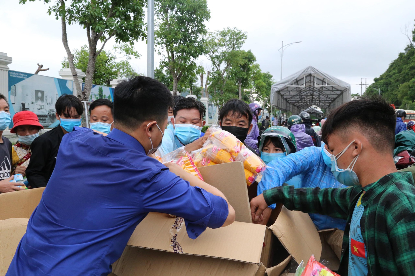 "Áo xanh" không quản nắng mưa trao tận tay những phần quà cho người đi đường. "Áo xanh" không quản nắng mưa trao tận tay những phần quà cho người đi đường.