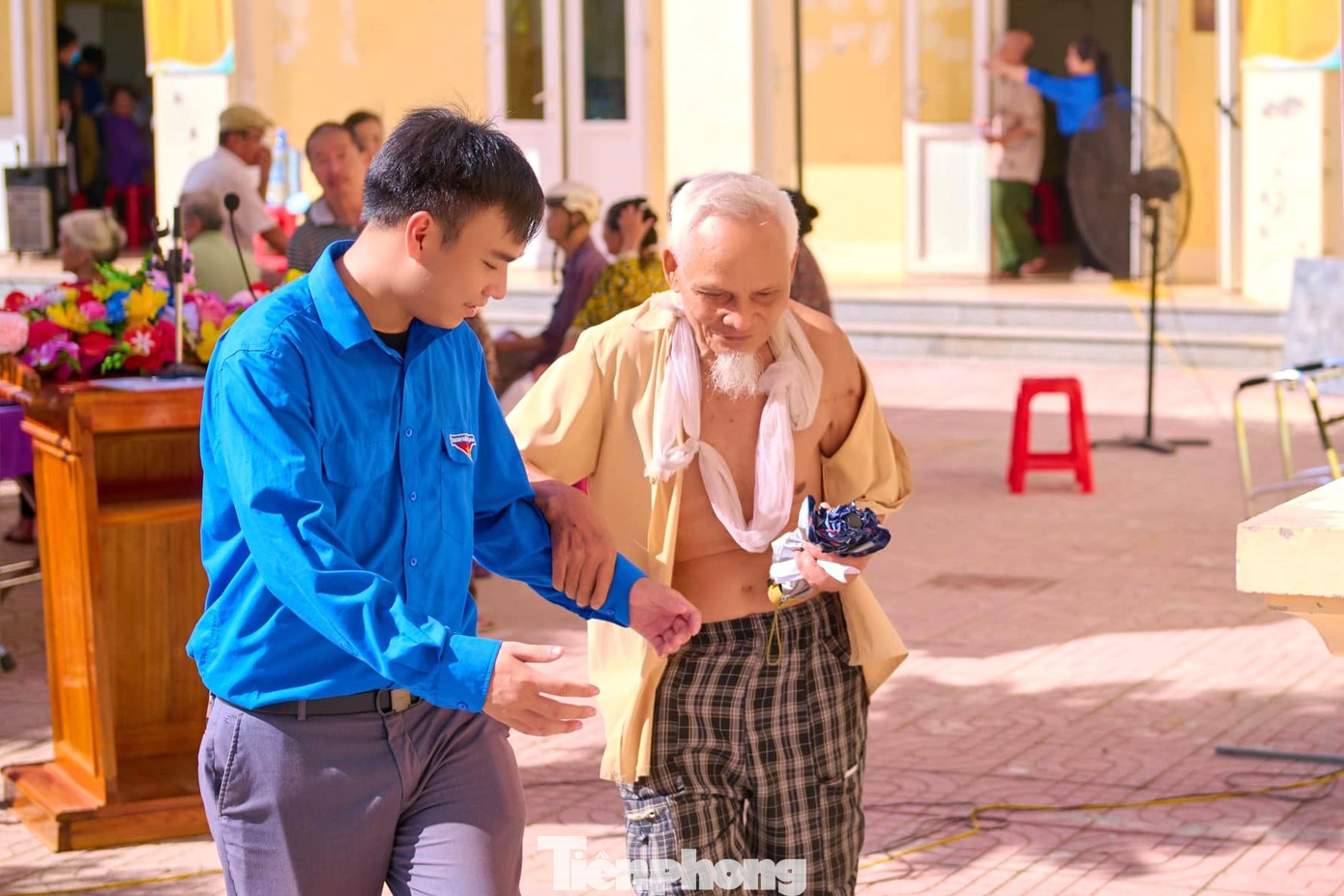 Hình ảnh đẹp đoàn viên thanh niên hỗ trợ dìu người có công với cách mạng đến điểm khám bệnh và cấp phát thuốc miễn phí.