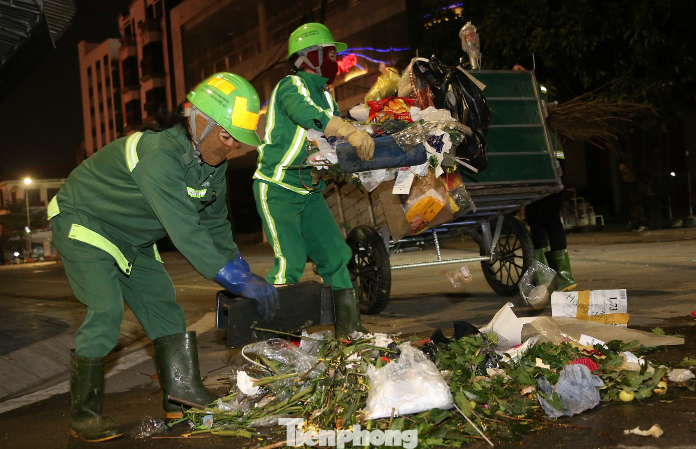 Những nữ công nhân môi trường khẩn trương thu gom rác lên xe lôi để vận chuyển đến điểm tập kết.