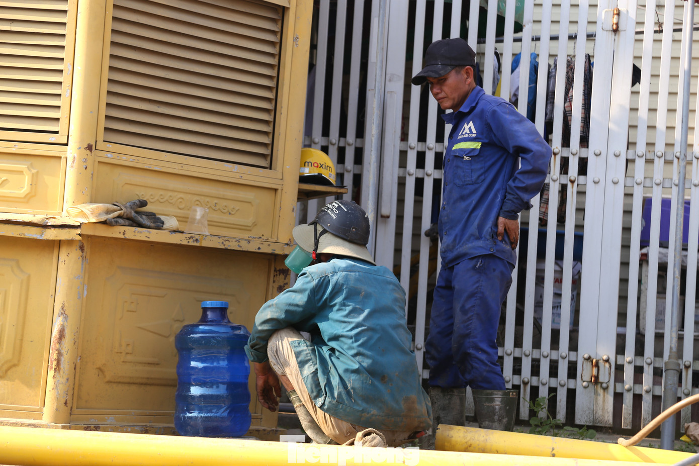 Công nhân tìm bóng râm để tránh nắng, đồng thời liên tục uống nước để tránh mất sức. Công nhân tìm bóng râm để tránh nắng, đồng thời liên tục uống nước để tránh mất sức.